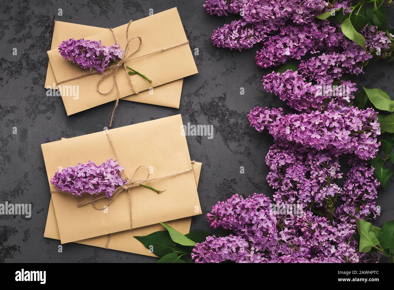 Primavera celebrazione sfondo, lilla e artigianato buste vista dall'alto Foto Stock