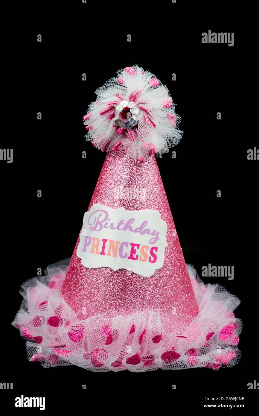 Un cappello da festa rosa glittery con le parole principessa di compleanno su di esso isolato su uno sfondo nero Foto Stock