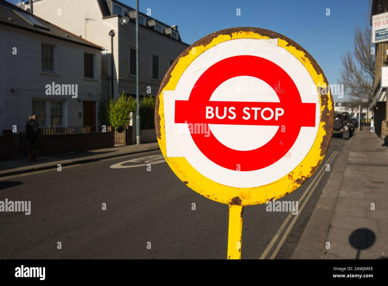 Arrugginimento, temporaneo, segno di fermata dell'autobus giallo su una strada a Londra Foto Stock