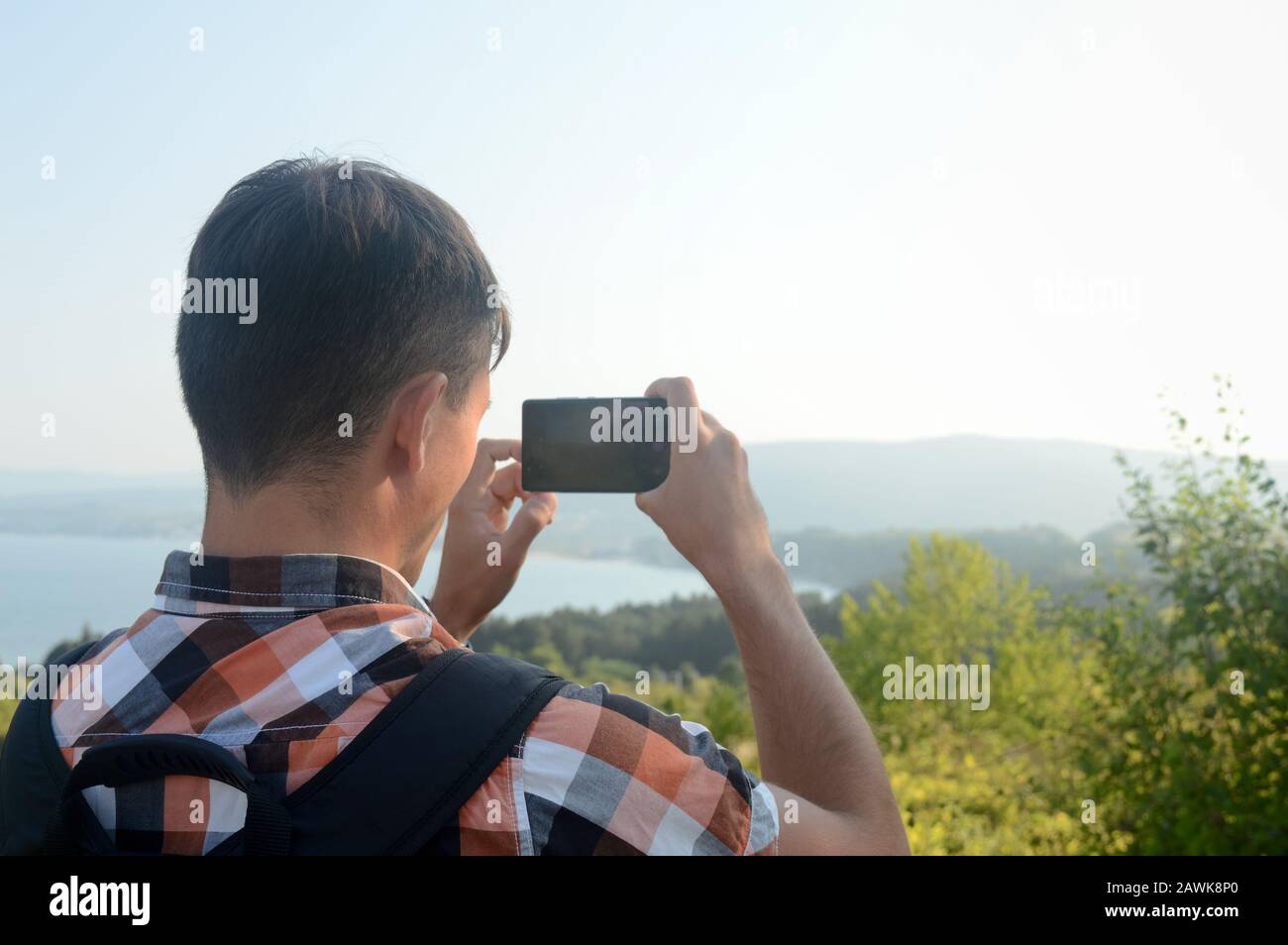 Un giovane, un turista con smartphone, esplora nuovi luoghi e scatta foto e fa un video della vacanza estiva da condividere sui social network Foto Stock