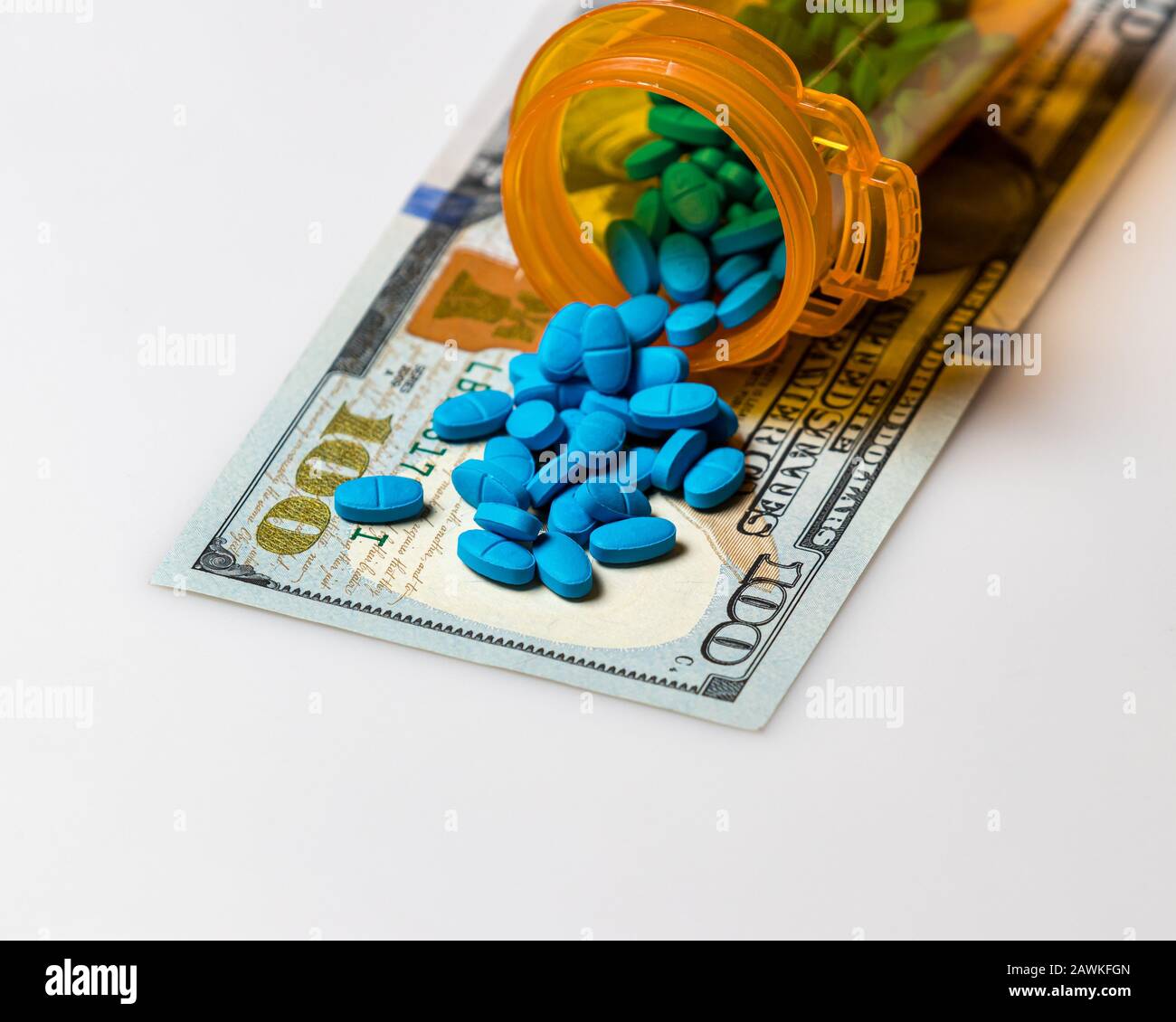 Flacone di pillola di prescrizione con 100 dollari di fattura isolato su sfondo bianco. Concetto di aumento dei costi di droga, medici, assicurativi e sanitari Foto Stock