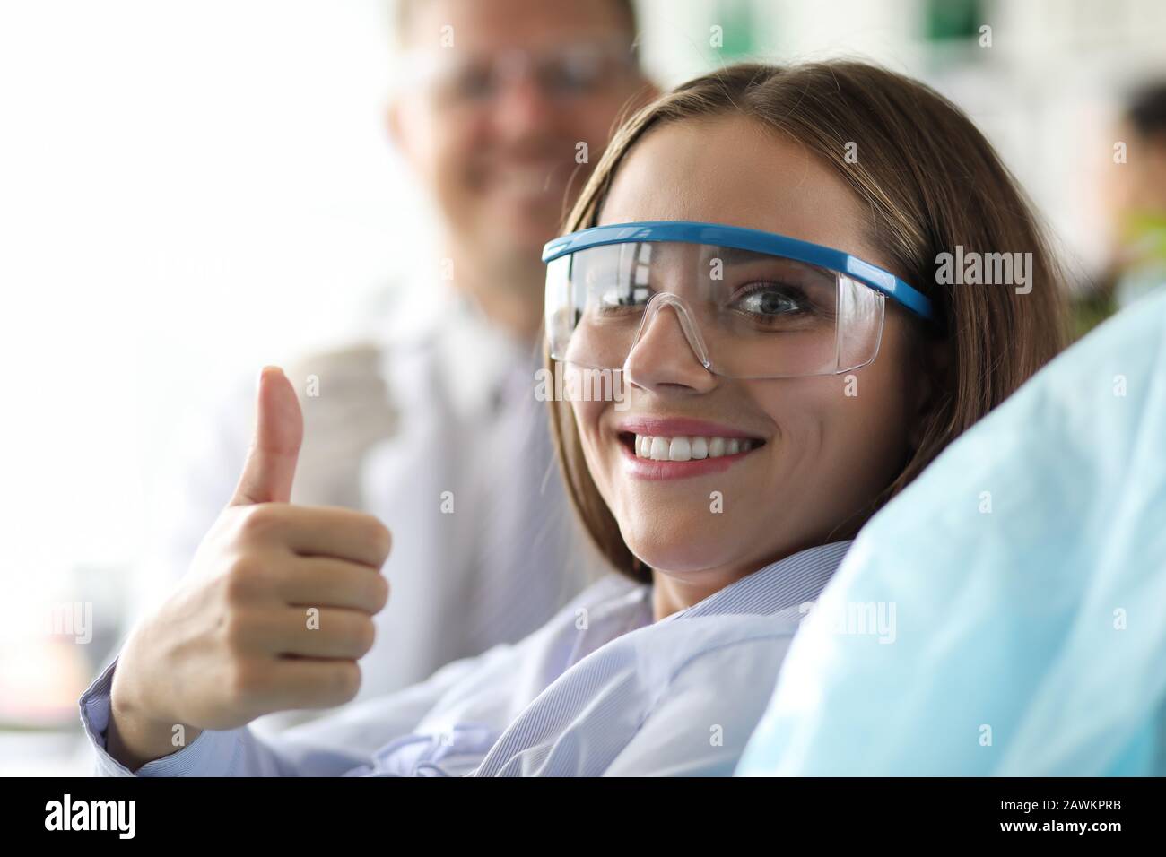 Visita dentista, ragazza in clinica mostra gesto ok. Foto Stock