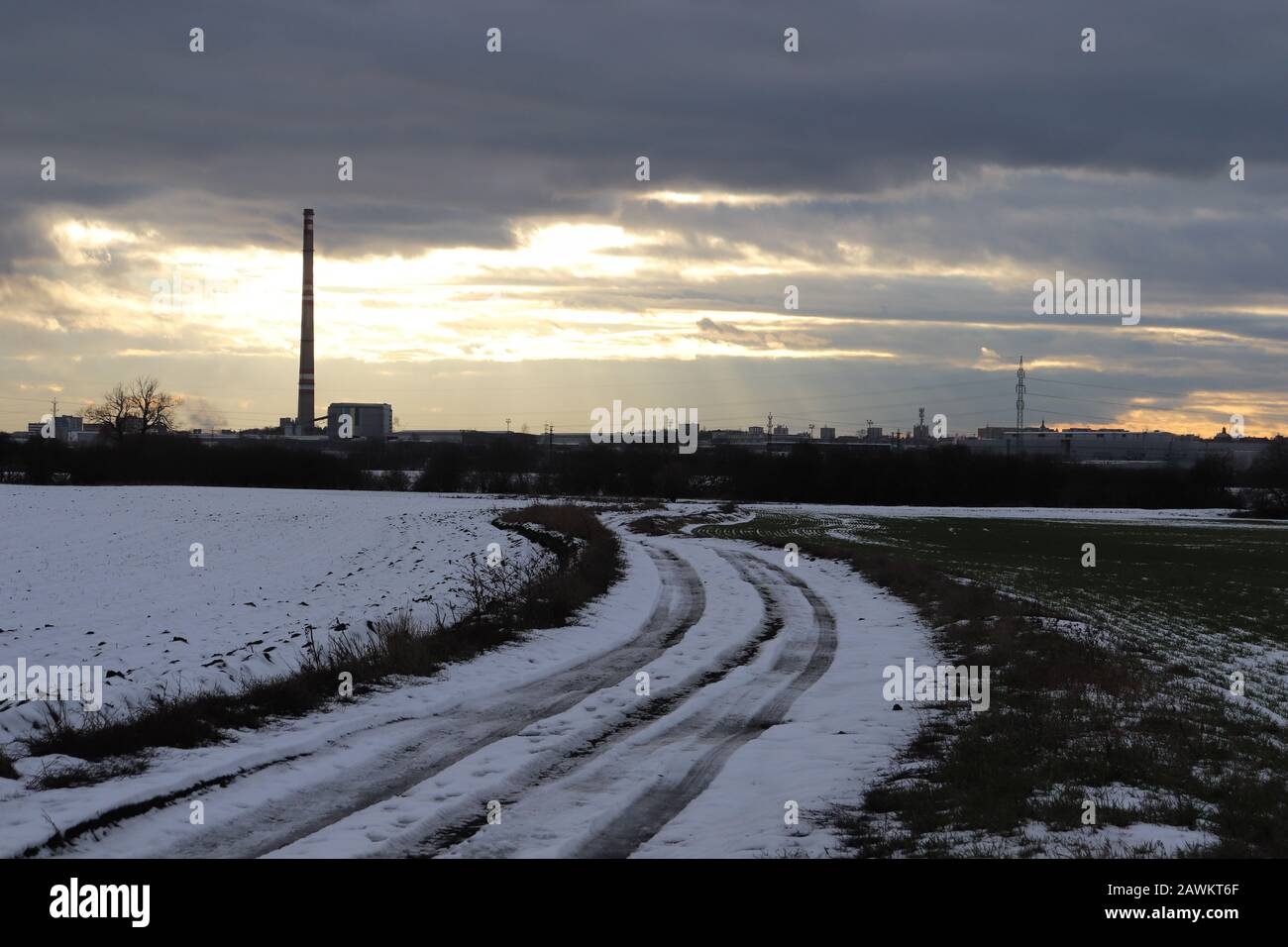 Una strada coperta di neve vicino alla città di Mladá Boleslav, Repubblica Ceca, con Škoda fabbrica di auto sullo sfondo. Foto Stock