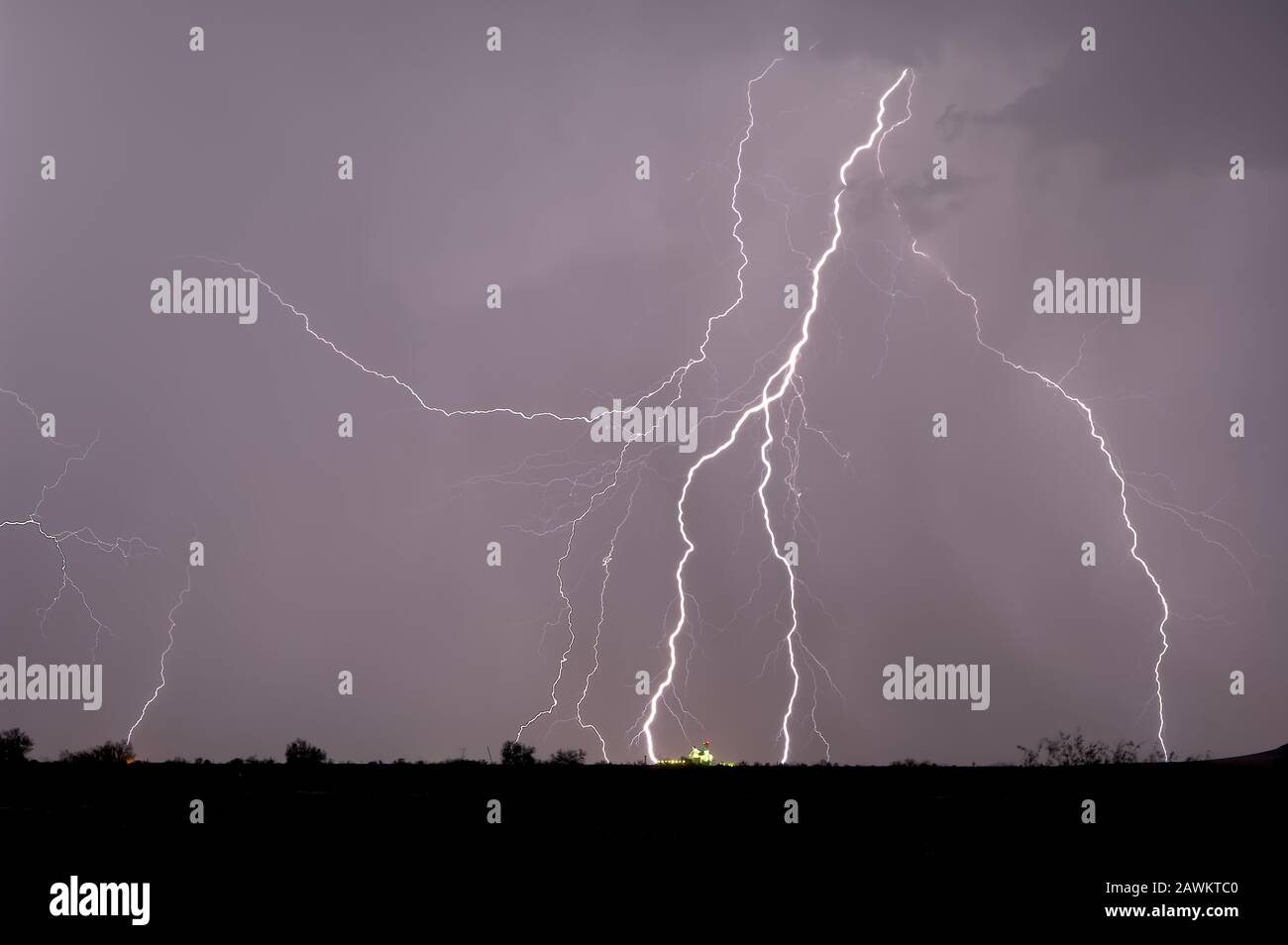 Fulmini multipli colpisce vicino e in un silo di fattoria in lontananza durante una tempesta del 2014 Arizona Monsoon. Foto Stock