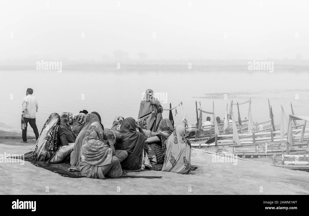 Gruppo di pellegrini indù in attesa di prendere il traghetto per attraversare il fiume Yamuna la mattina misty durante il pellegrinaggio a Vrindavan, Uttar Pradesh, India. Foto Stock