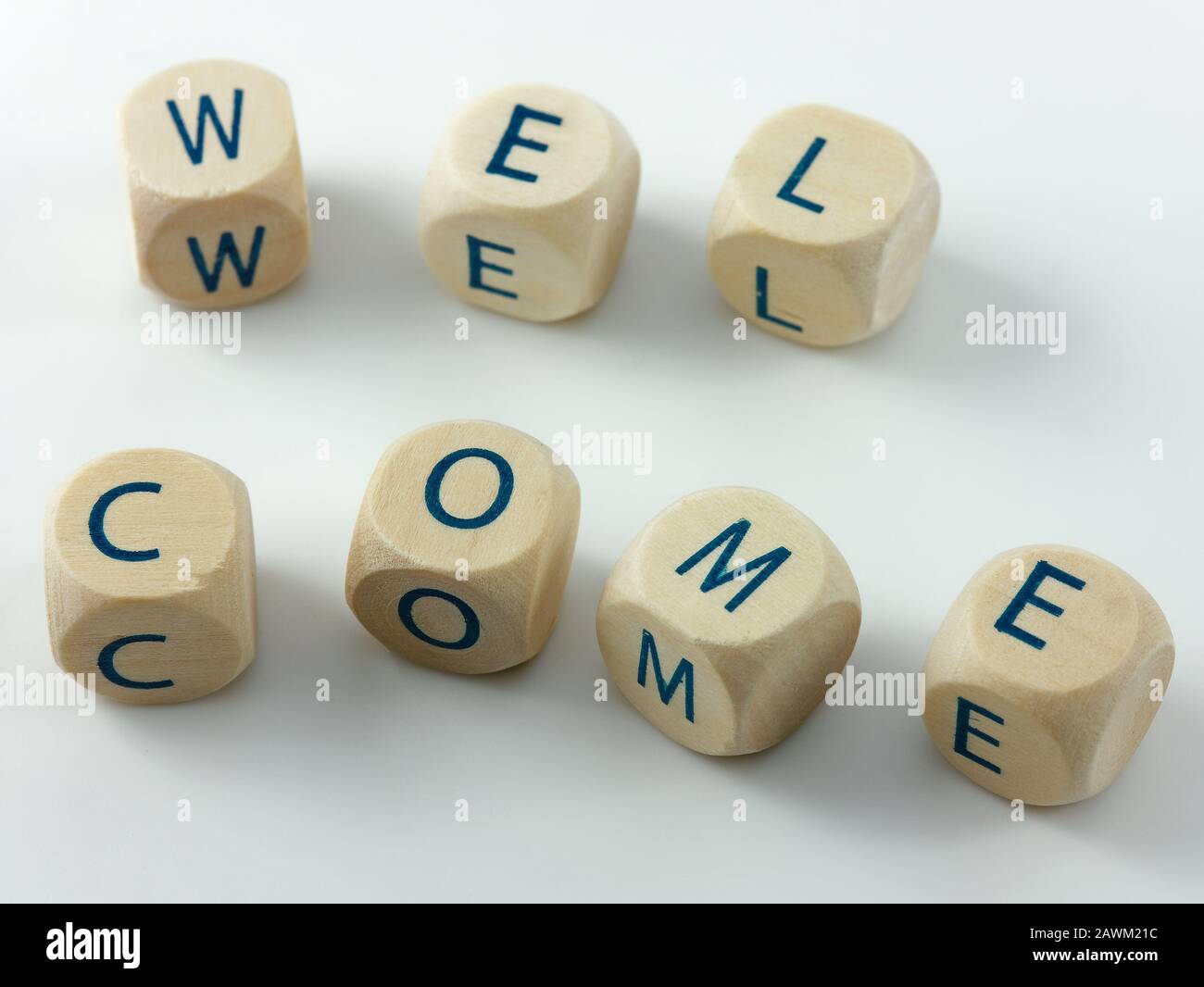 Benvenuti scritto in cubetti di legno su una scrivania bianca Foto Stock