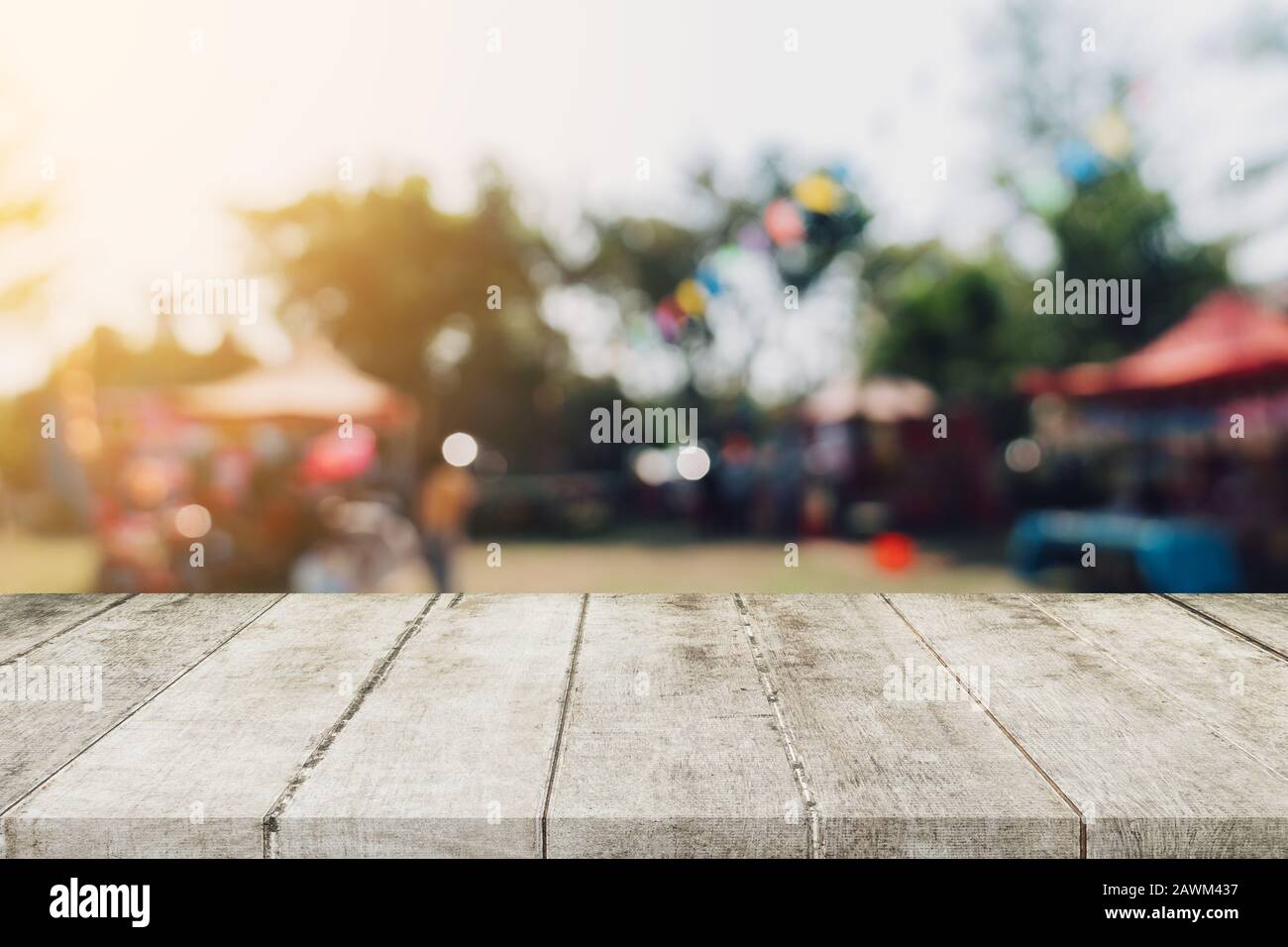 Svuotare tavolo in legno e defocalizzata bokeh di fondo e la sfocatura sullo sfondo di un giardino di alberi nella luce solare, display montage per prodotto. Foto Stock