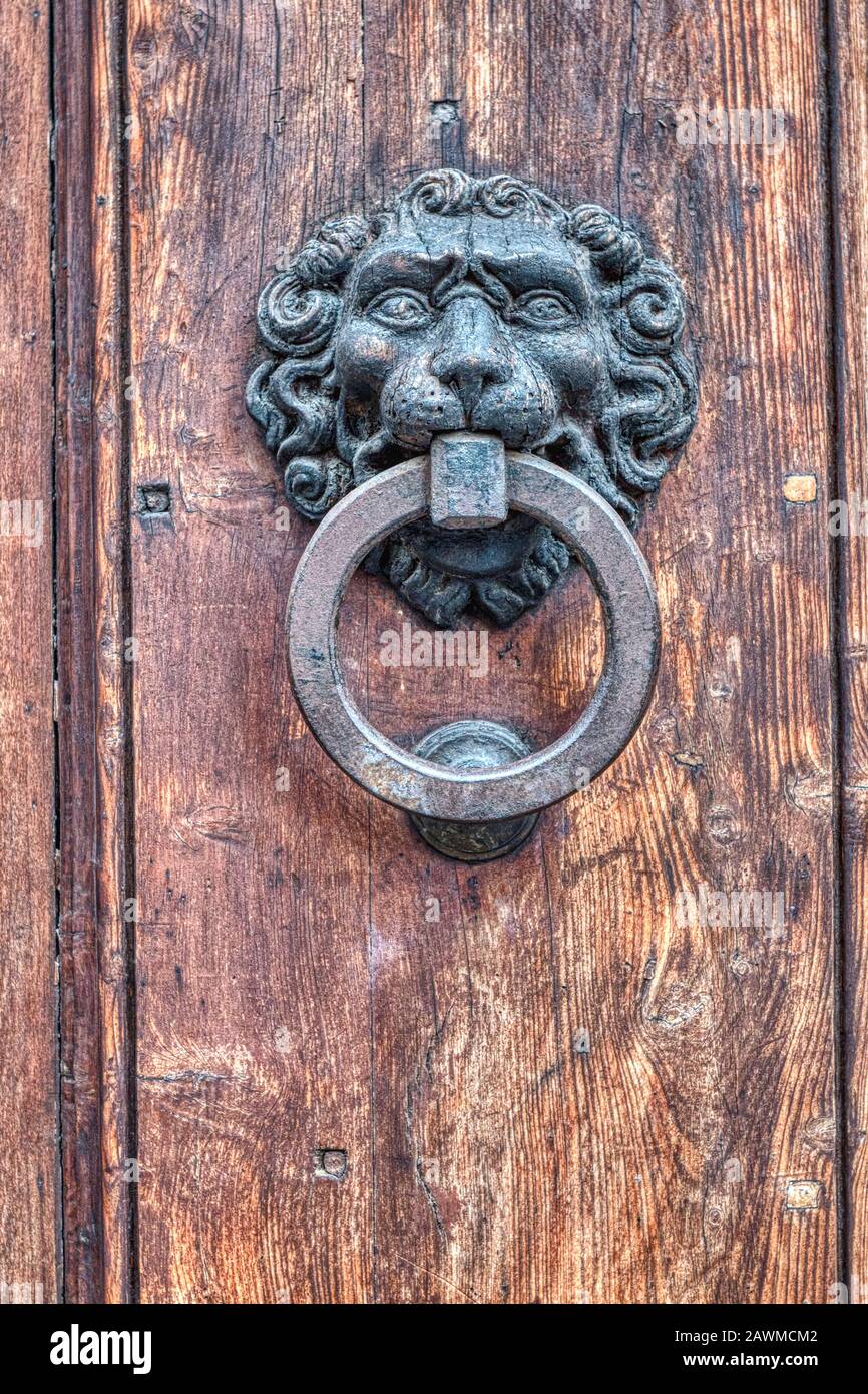 dettaglio di un antico leone testa ferro bussare su una porta di legno Foto Stock