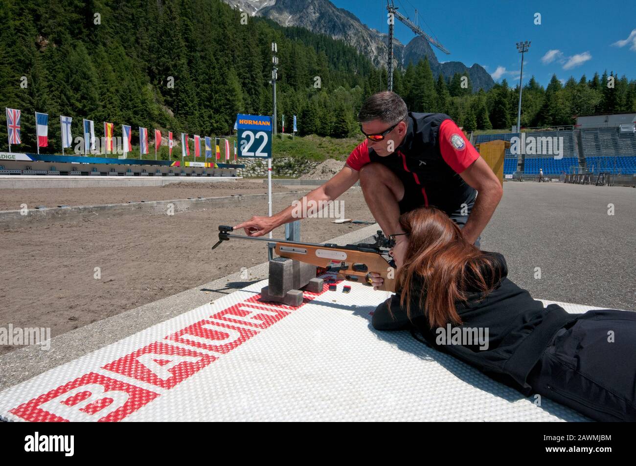 Istruttore che insegna ai visitatori a sparare con il fucile da biathlon nel Centro Biathlon Anterselva, Valle Anterselva (Anterolzertal), Trentino Alto Adige Foto Stock