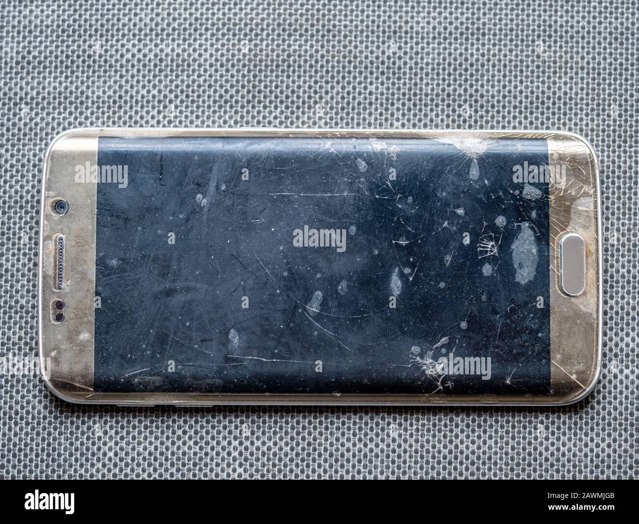 Lo smartphone cade sul pavimento e lo schermo è danneggiato isolato. Foto Stock