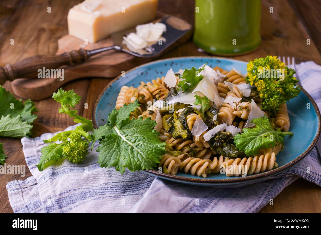 Cime di rapa in un piatto con parmigiano su un tavolo di legno. Cucina tradizionale del sud d'Italia, dalla Puglia. Foto in stile rustico. Spazio di copia. Foto Stock