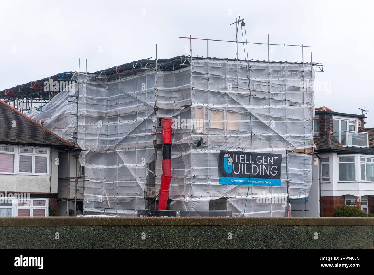 Impalcatura con strati meteorologici strappati via come tempesta Ciara colpisce il tempo a Southend on Sea, Essex, UK. Edificio Intelligente. Fogli di detriti Foto Stock