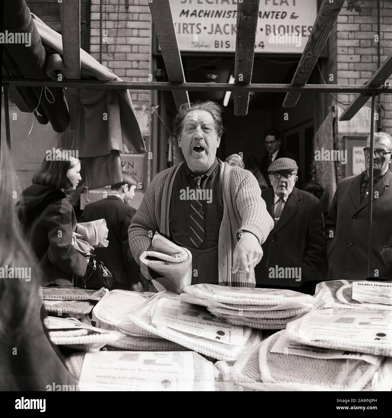 Business Brisk al Petticoat Lane Market nella zona est di Londra. L'uomo sta vendendo le coperture per i sedili della toletta. Foto Stock
