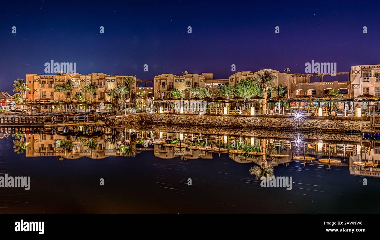 Hotel sul lungomare egiziano e ristoranti che riflettono nella laguna scura di notte, el Gouna, Egitto, 16 gennaio 2020 Foto Stock