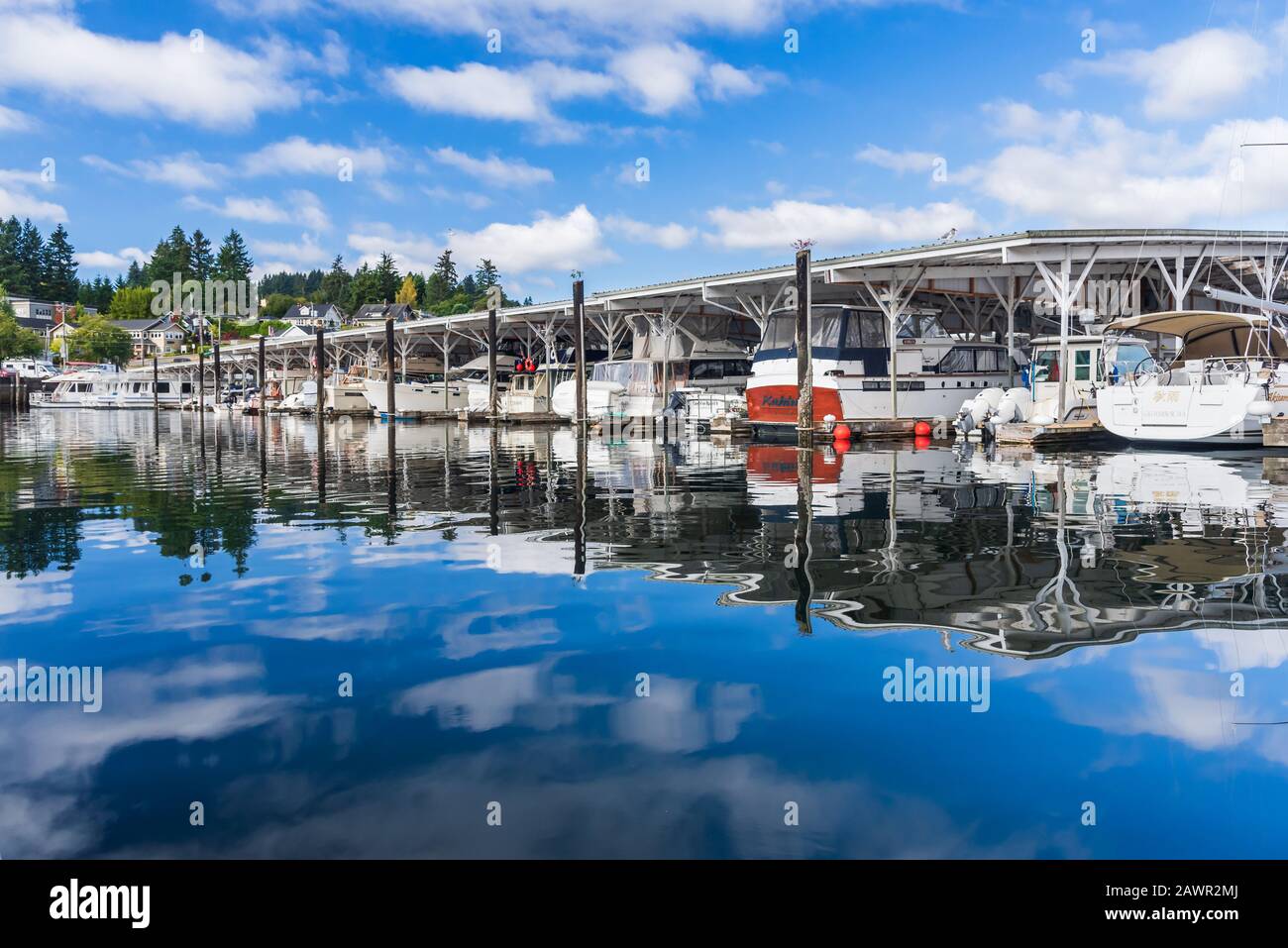 La mattina presto sopra la baia protetta di Gig Harbor, Washington con cieli blu e belle nuvole bianche Foto Stock