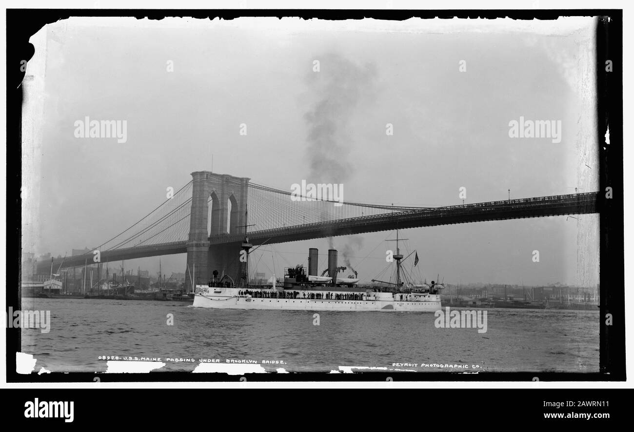 1898 ca, NEW YORK , USA : la marina U.S.S. Maine passando sotto il Ponte di Brooklyn, New York City. Il grande ponte sospeso East River, ha aperto la giornata Foto Stock