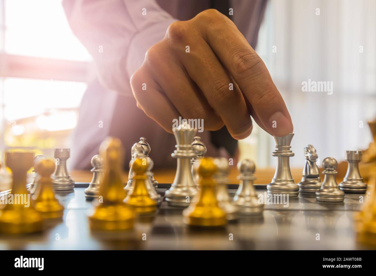 Gioco di scacchi sulla scacchiera dietro lo sfondo dell'uomo d'affari. Concetto di business per presentare informazioni finanziarie e analisi di strategia di marketing. Investmen Foto Stock