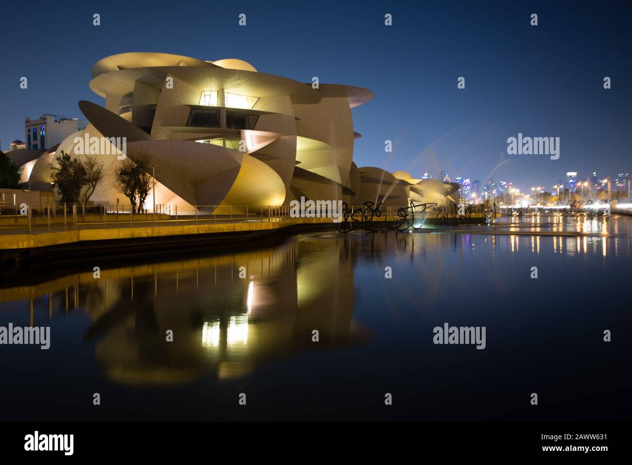 Il Museo Nazionale del Qatar si riflette in una piccola piscina esterna a Doha. Foto Stock