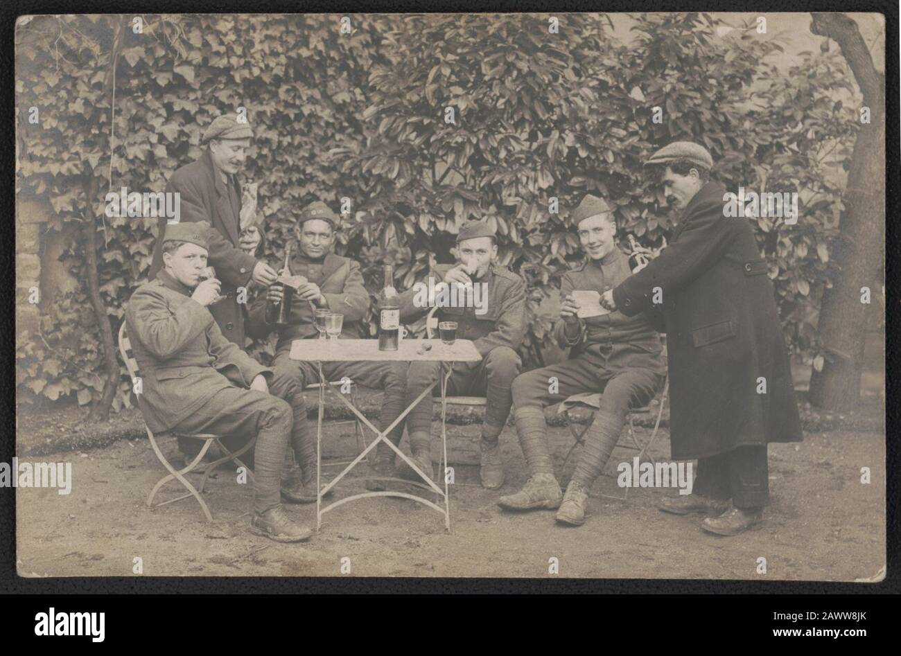 Quattro soldati non identificati in vino da bere uniforme come due civili li consegnano documenti, probabilmente in Francia Foto Stock