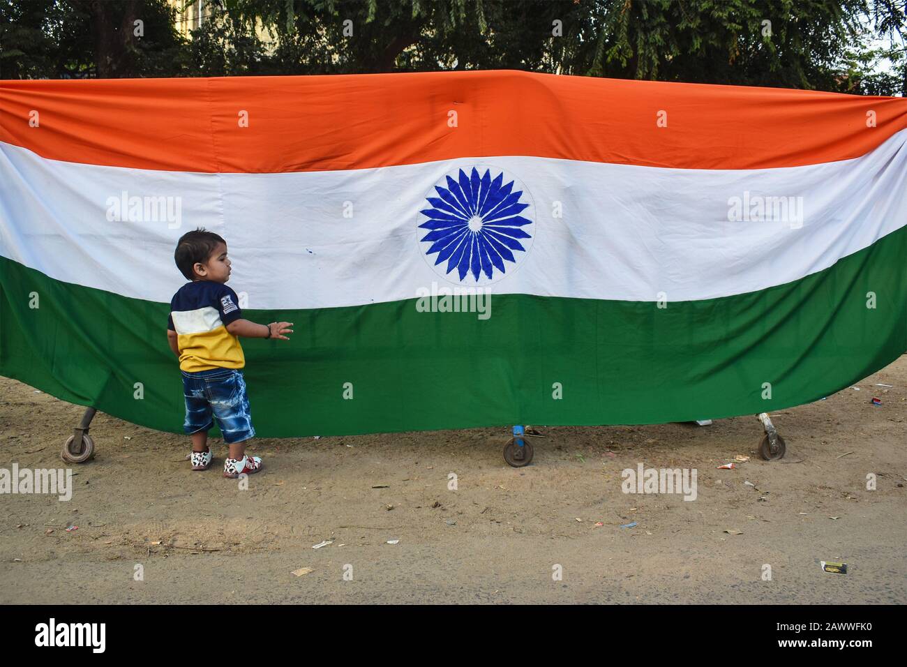Un toddler sta saccheggiare con la bandiera nazionale dell'India a Kolkata, India. Foto Stock