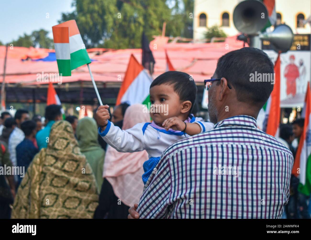 Un toddler che gioca con una bandiera nazionale dell'India sul raduno di protesta di NRC e CAA a Kolkata, India Foto Stock
