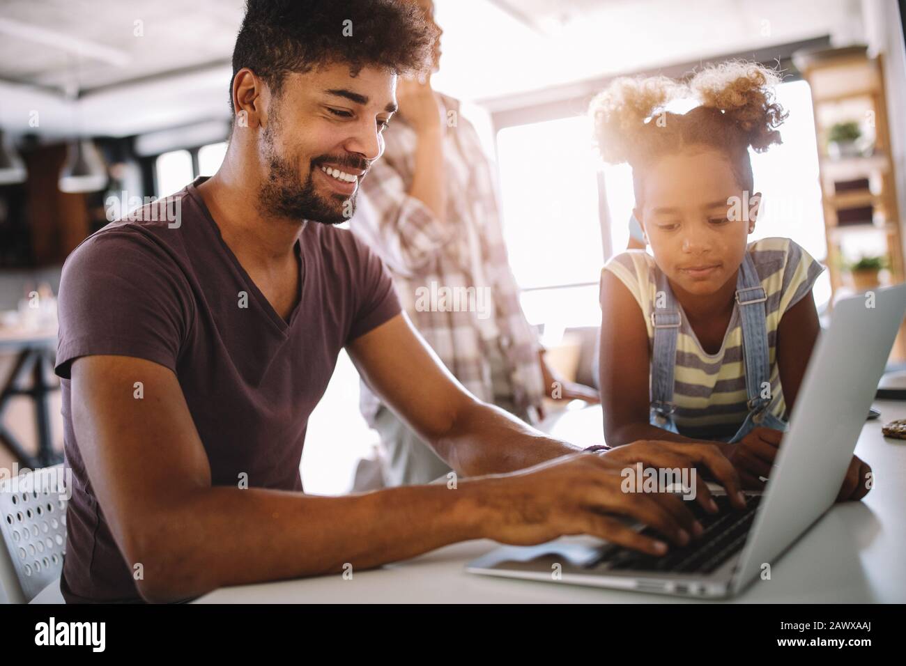 Padre e figlia che lavorano su laptop. Uomo d'affari che lavora da casa e guarda il bambino Foto Stock