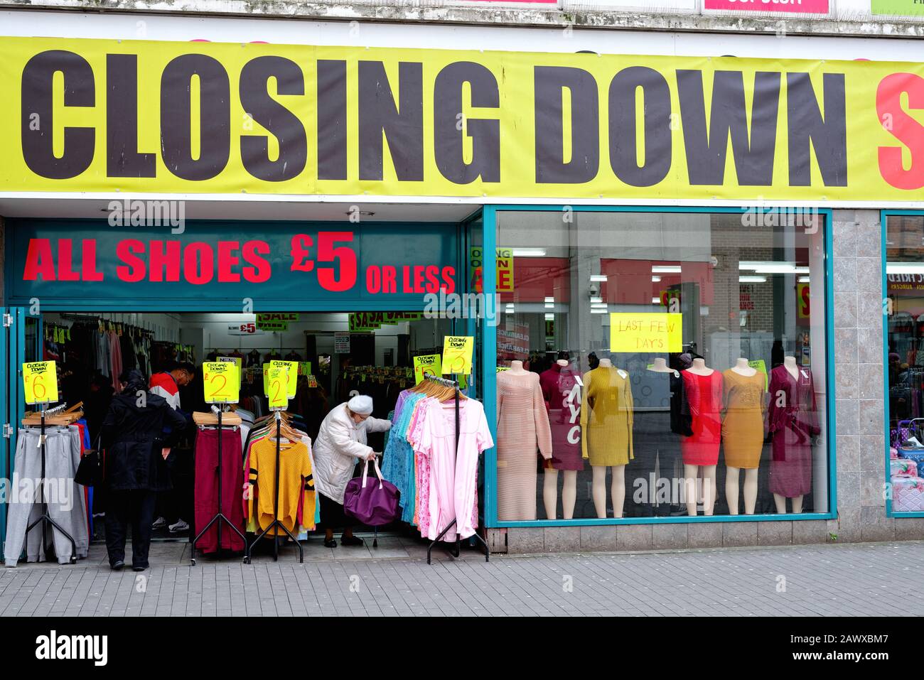 Davanti ad un negozio di abbigliamento economico con un grande cartello di chiusura sopra l'entrata sulla Hounslow High Street, West London England UK Foto Stock