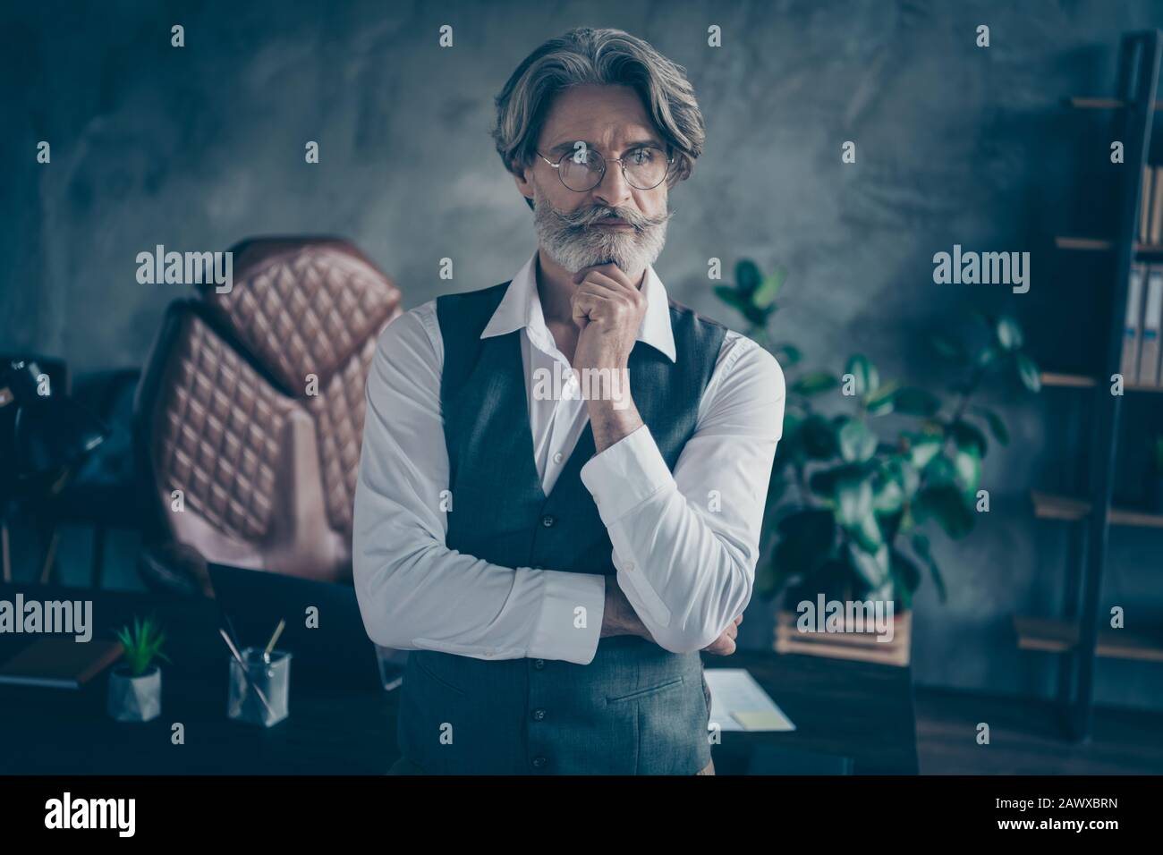 Primo piano ritratto del suo bello attraente chic esperto esperto in capelli grigi uomo esperto di pensiero squalo toccante mento al loft moderno Foto Stock