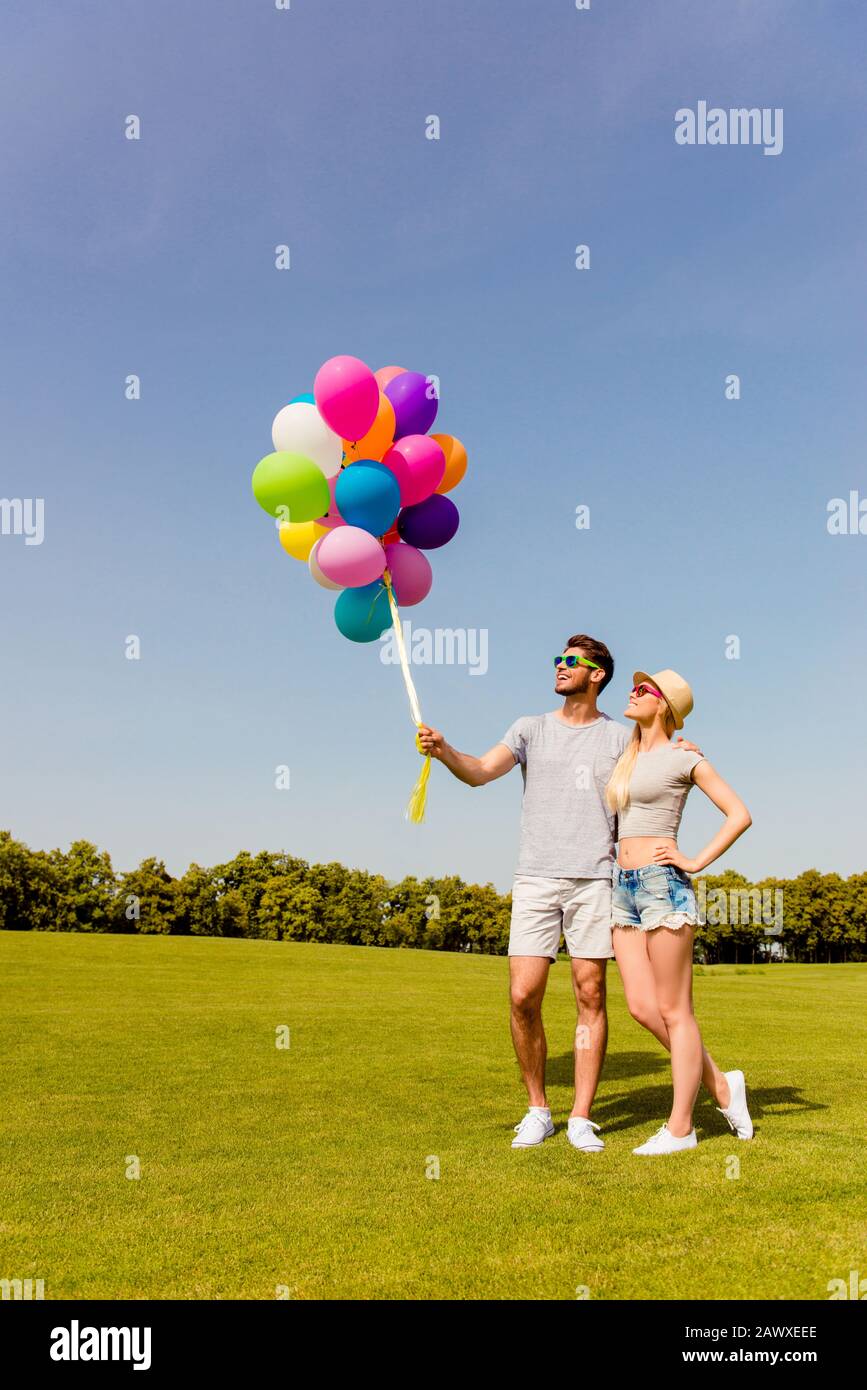 Giovane coppia felice in amore camminare nel parco con palloncini Foto Stock