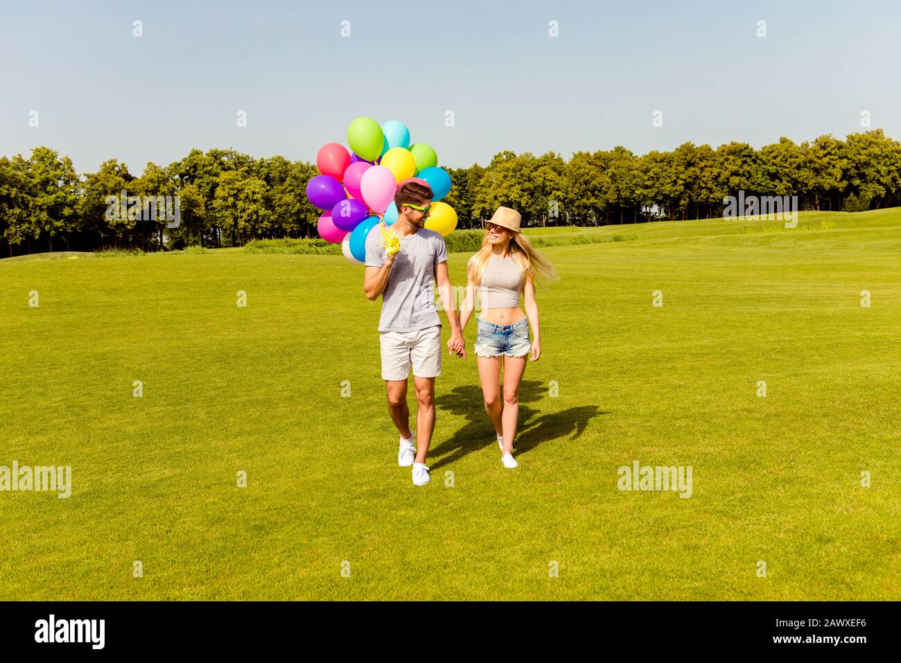 Giovane felice bella famiglia che ha fine settimana e camminare con palloncini Foto Stock