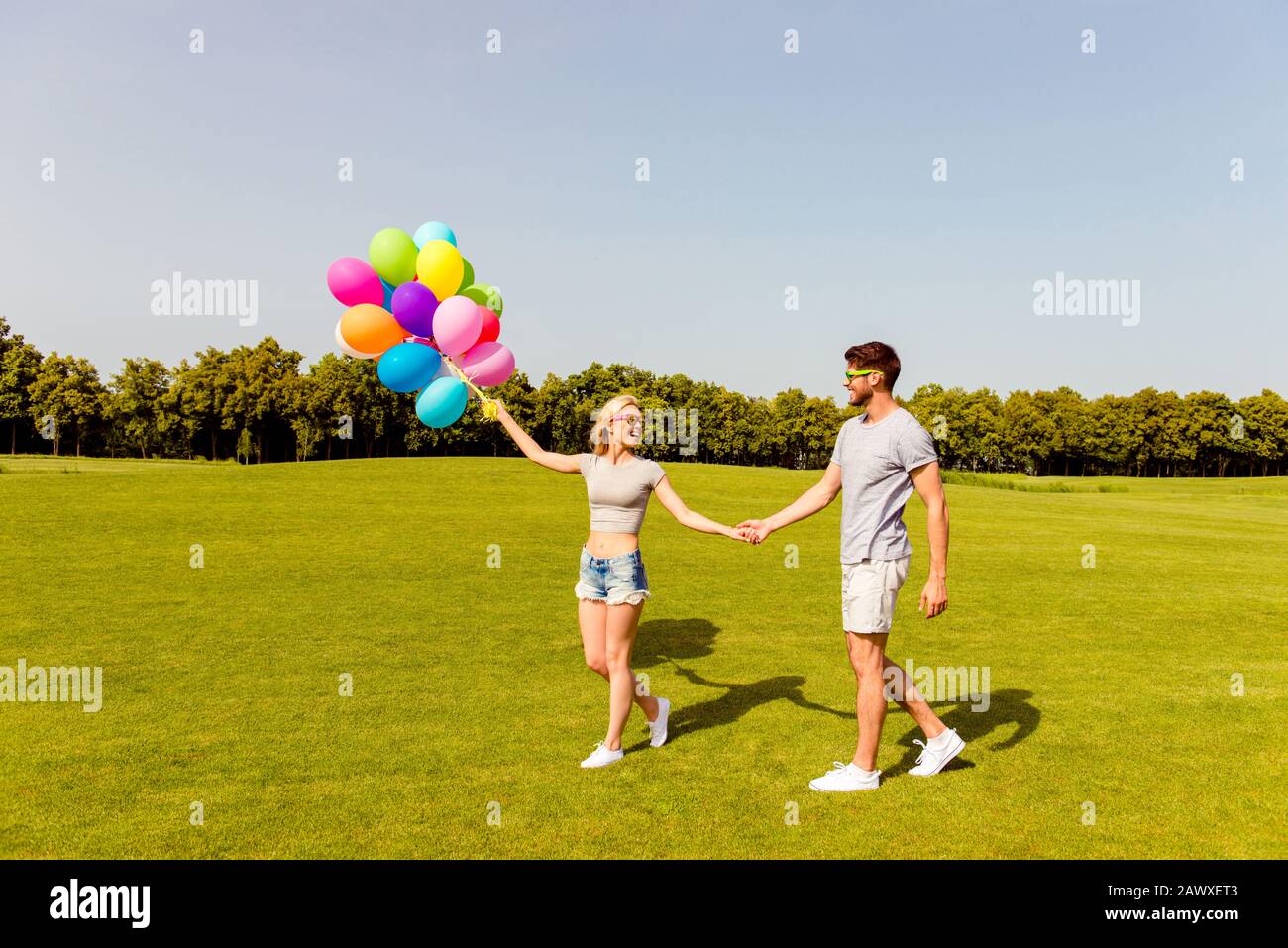 Giovane famiglia felice che ha passeggiata romantica con palloncini Foto Stock
