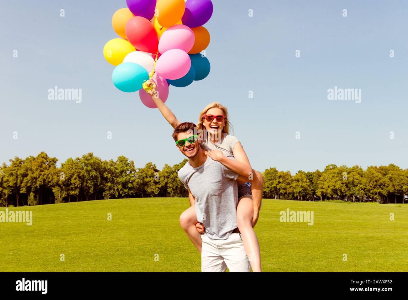 Ritratto di felice uomo piggybacking la sua ragazza e divertirsi Foto Stock