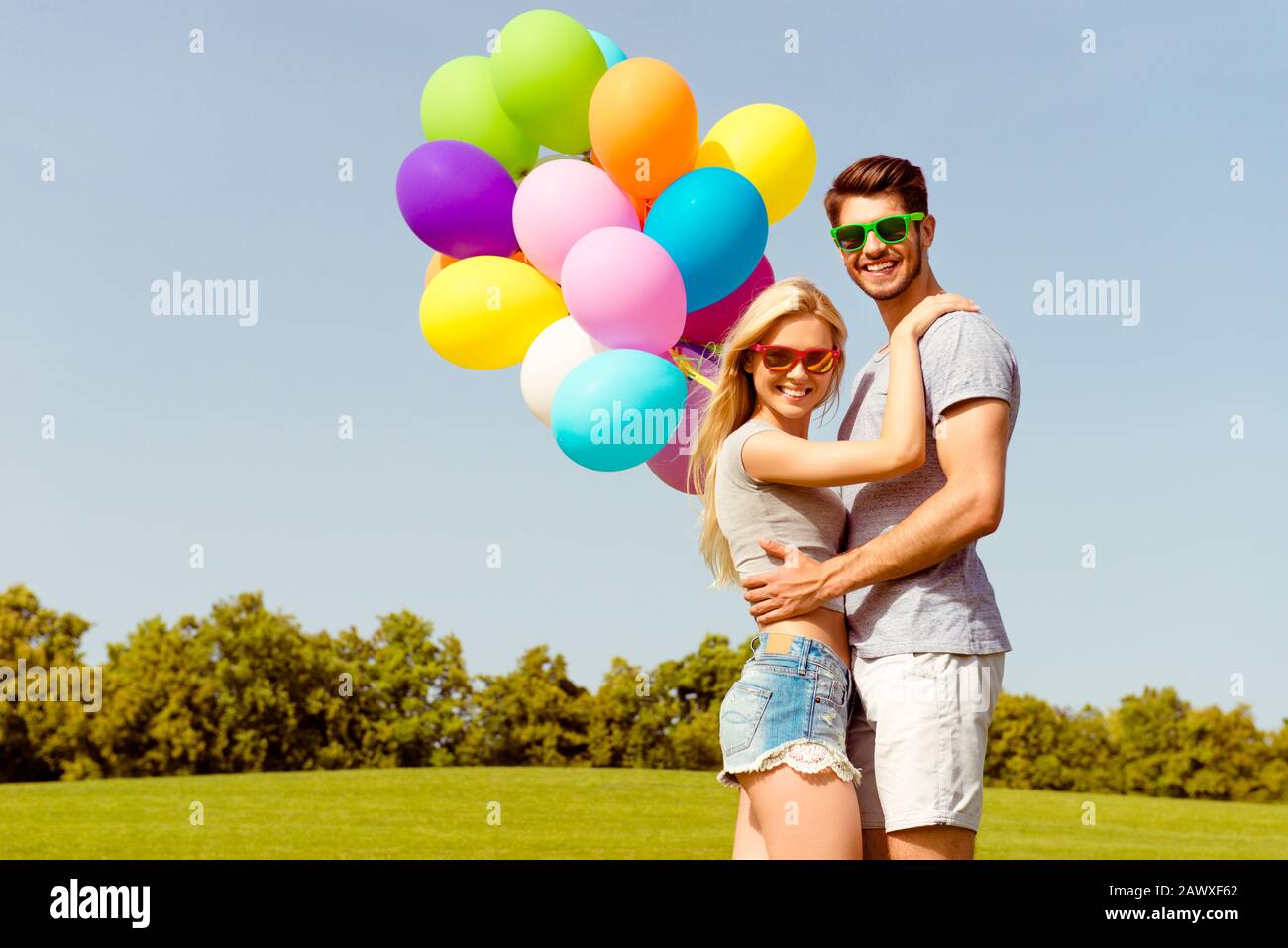 Ritratto di felice romantica coppia bella datare nel parco con palloncini Foto Stock