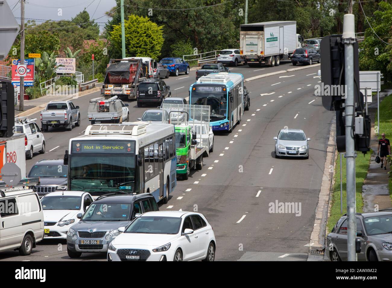 Traffico di Sydney su una strada in guerra, Dee Why, Australia, autobus e auto attendono al semaforo Foto Stock