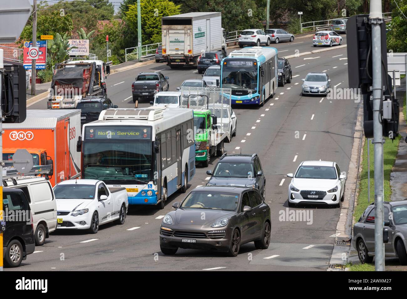 Traffico di Sydney su una strada in guerra, Dee Why, Australia, autobus e auto attendono al semaforo Foto Stock