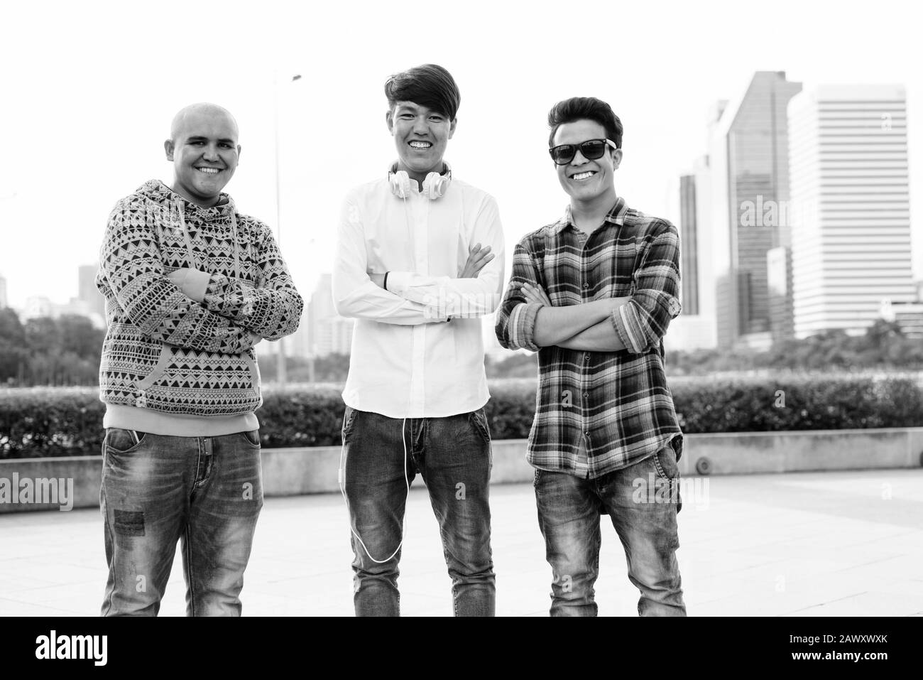 Tre giovani uomini asiatici di relax presso il parco insieme Foto Stock