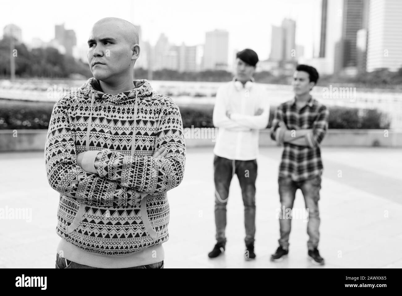 Tre giovani uomini asiatici di relax presso il parco insieme Foto Stock