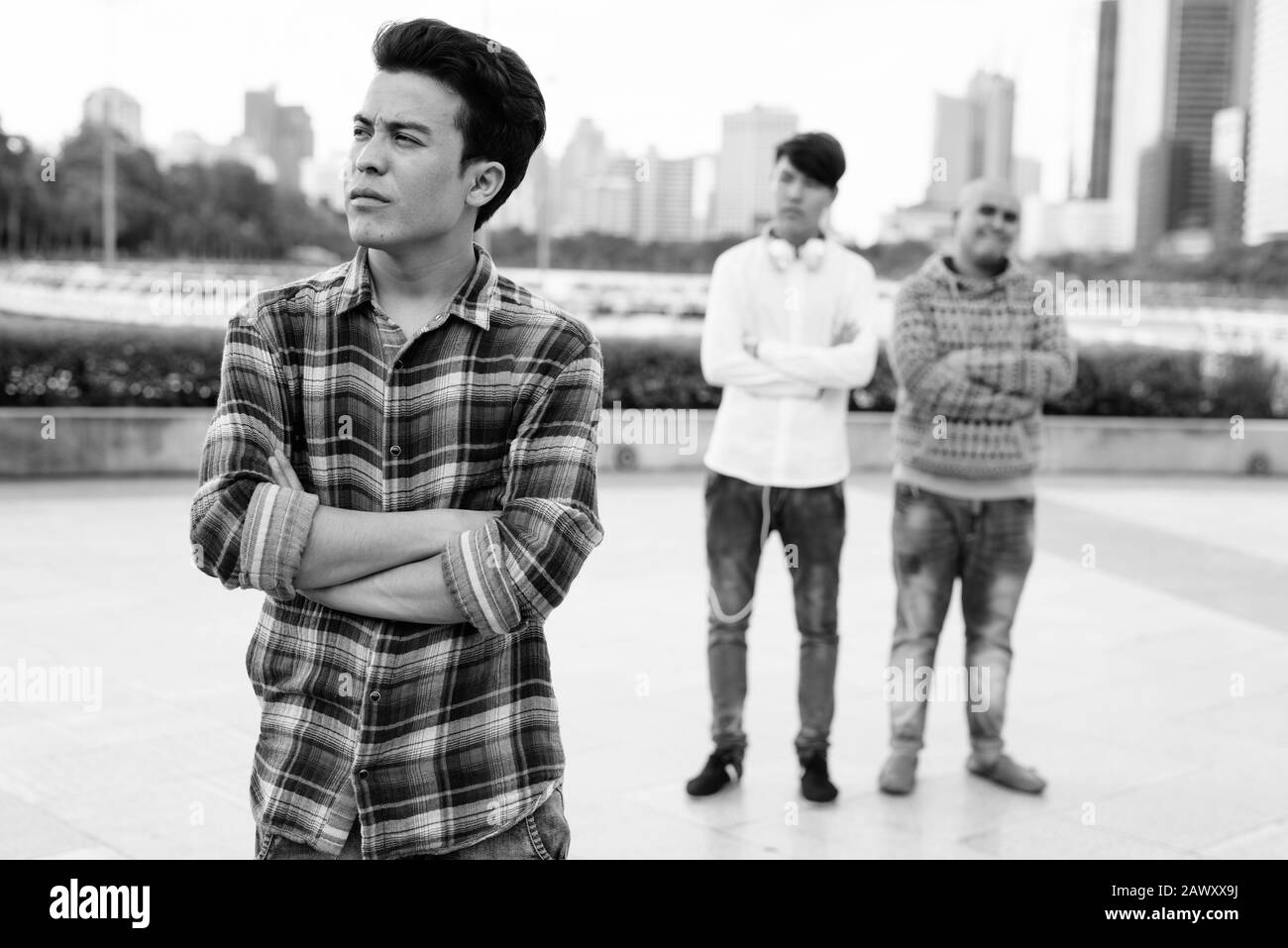 Tre giovani uomini asiatici di relax presso il parco insieme Foto Stock