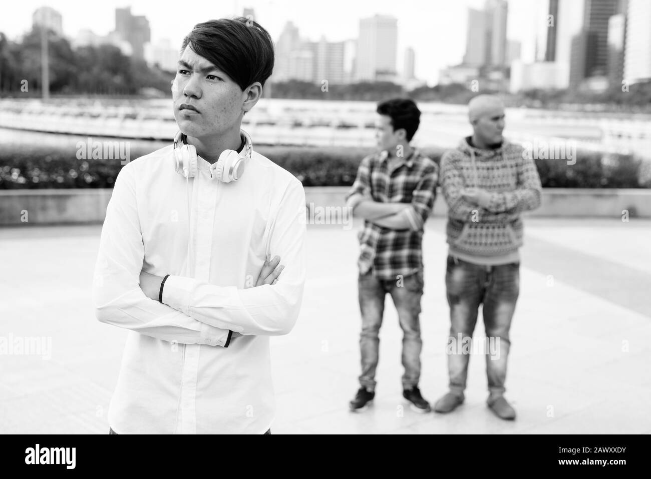 Tre giovani uomini asiatici di relax presso il parco insieme Foto Stock