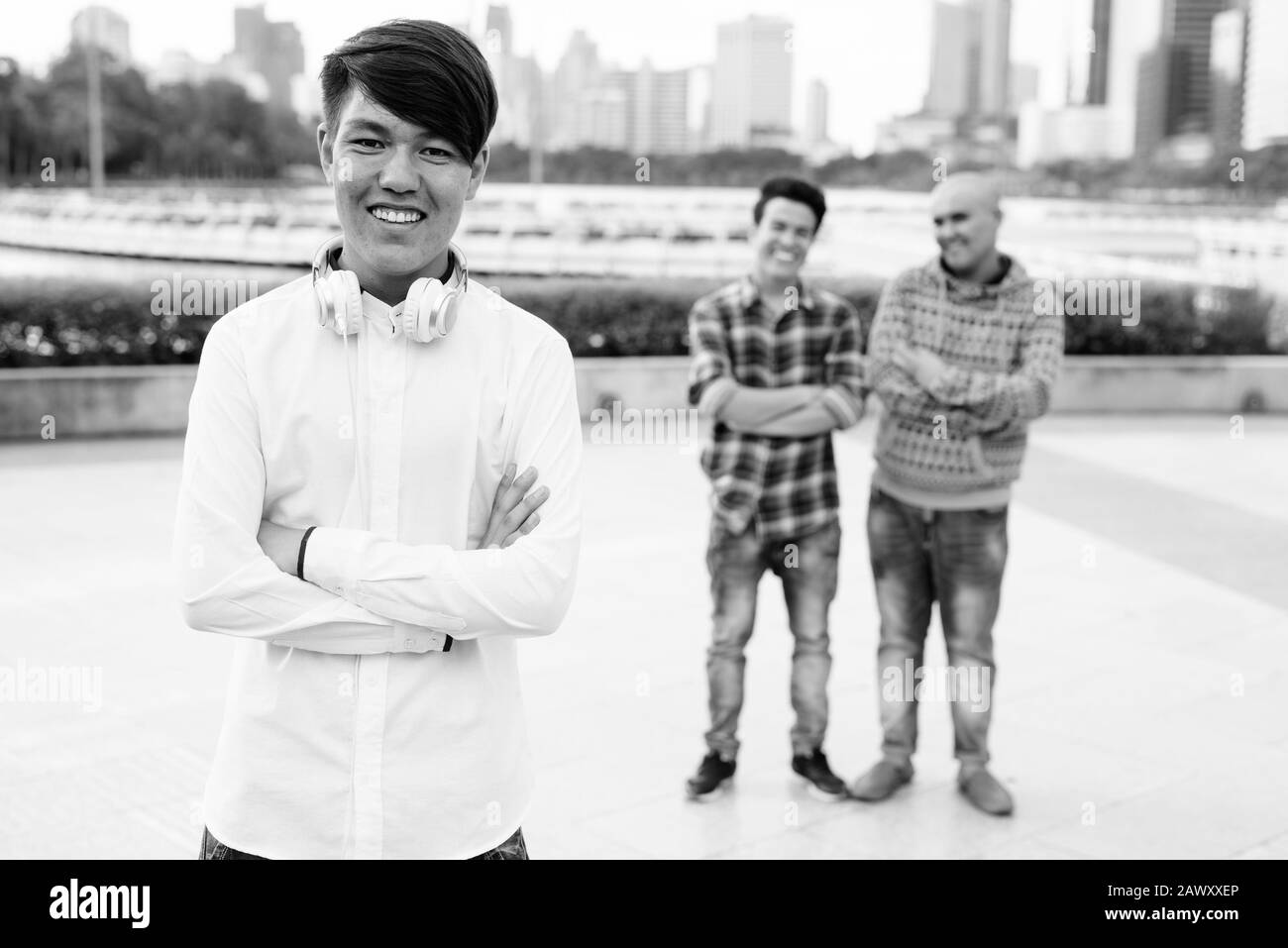 Tre giovani uomini asiatici di relax presso il parco insieme Foto Stock