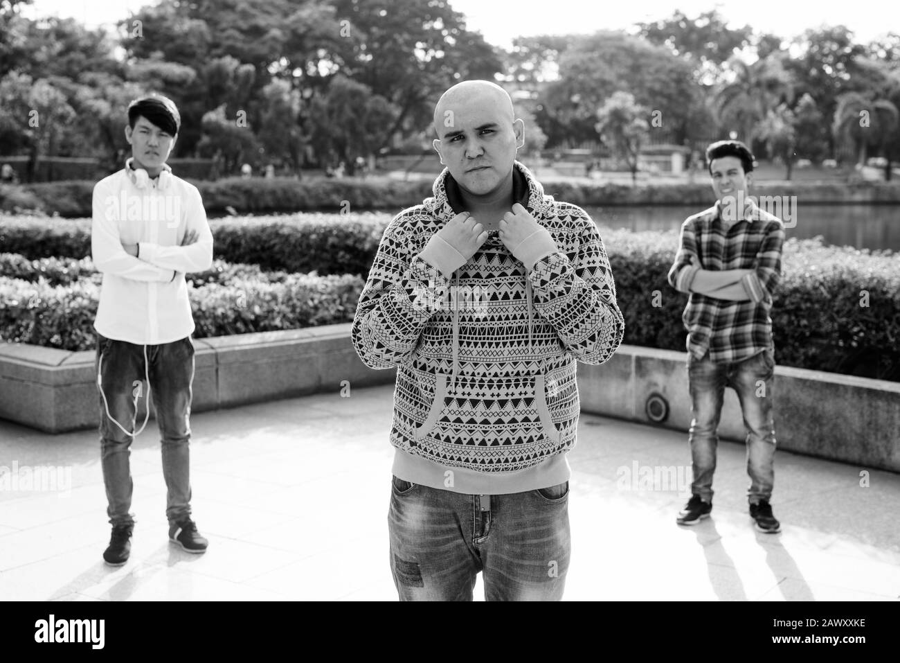 Tre giovani uomini asiatici di relax presso il parco insieme Foto Stock