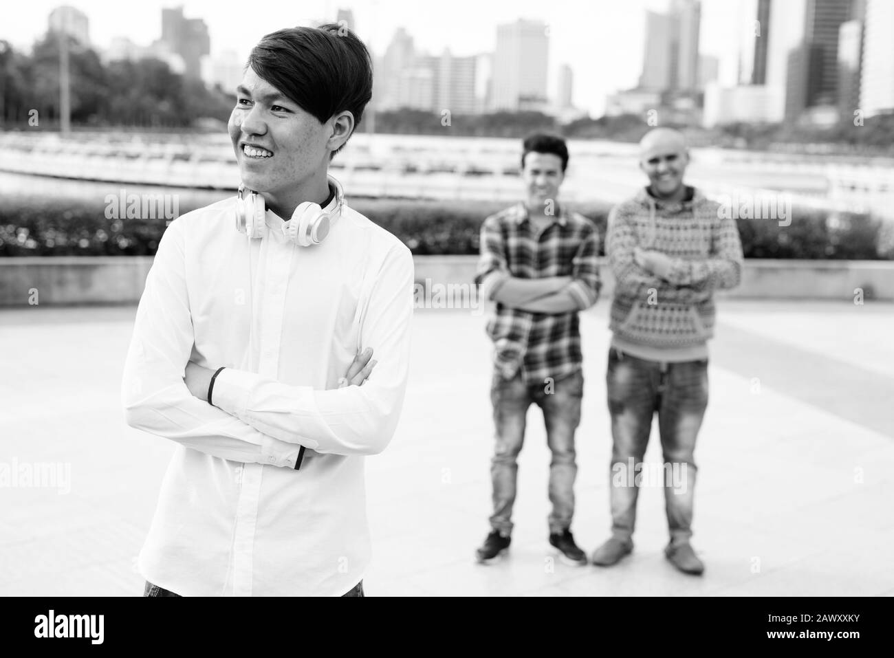 Tre giovani uomini asiatici di relax presso il parco insieme Foto Stock