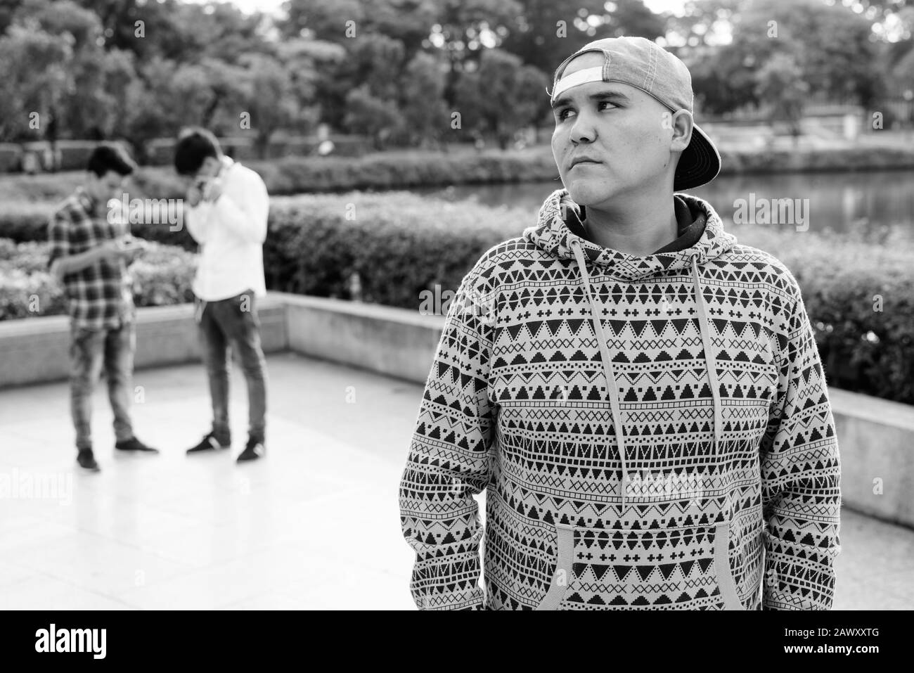 Tre giovani uomini asiatici di relax presso il parco insieme Foto Stock