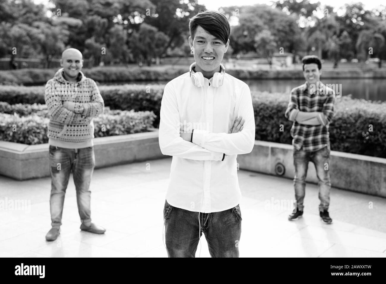 Tre giovani uomini asiatici di relax presso il parco insieme Foto Stock