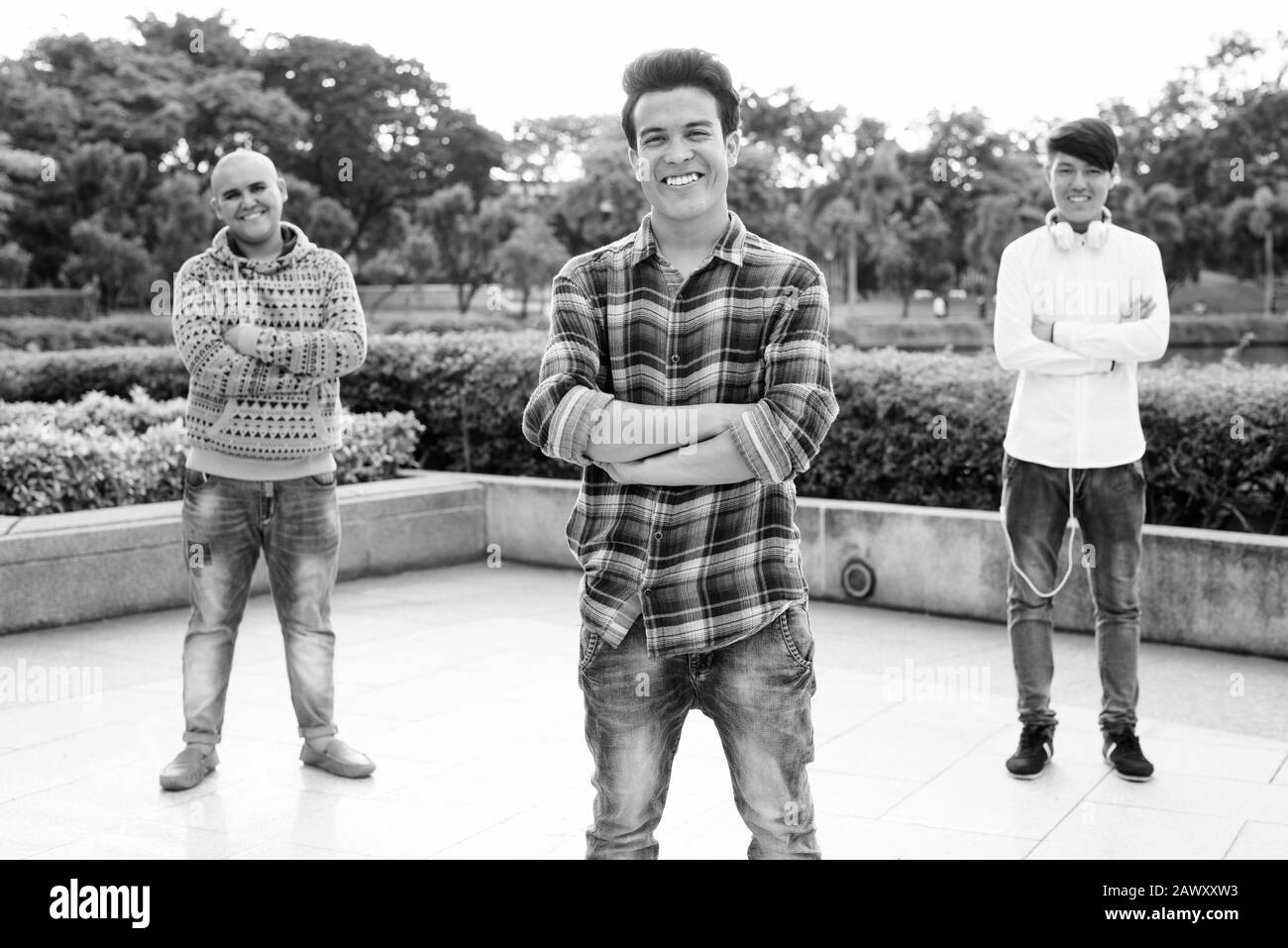 Tre giovani uomini asiatici di relax presso il parco insieme Foto Stock