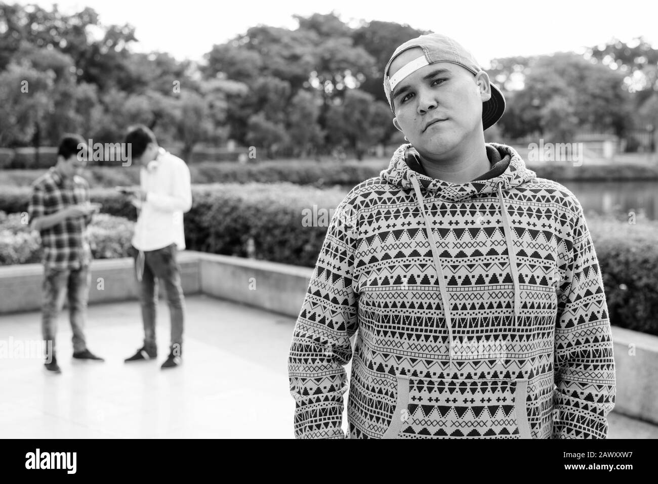 Tre giovani uomini asiatici di relax presso il parco insieme Foto Stock