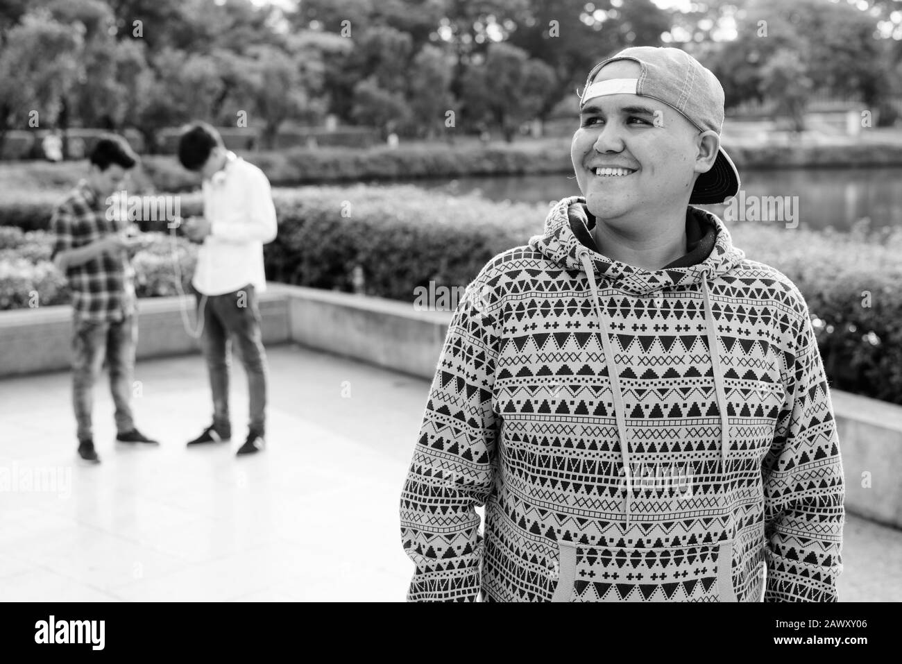 Tre giovani uomini asiatici di relax presso il parco insieme Foto Stock