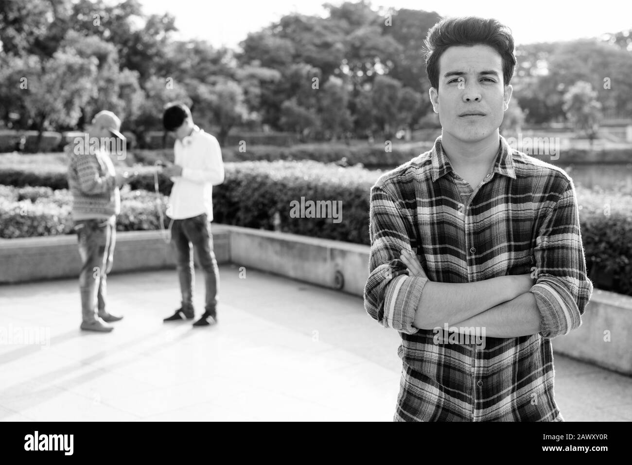 Tre giovani uomini asiatici di relax presso il parco insieme Foto Stock
