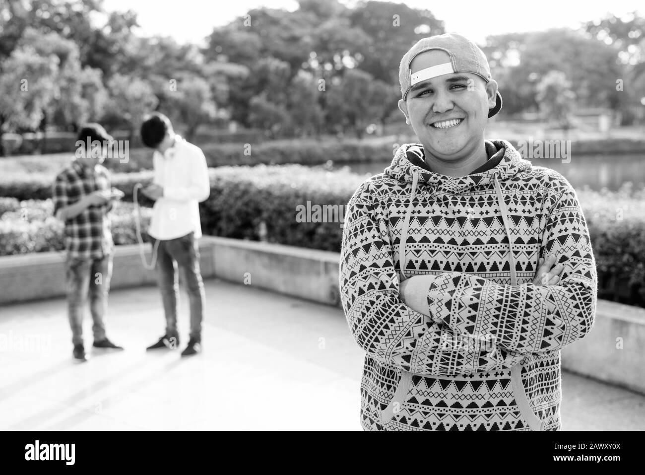 Tre giovani uomini asiatici di relax presso il parco insieme Foto Stock