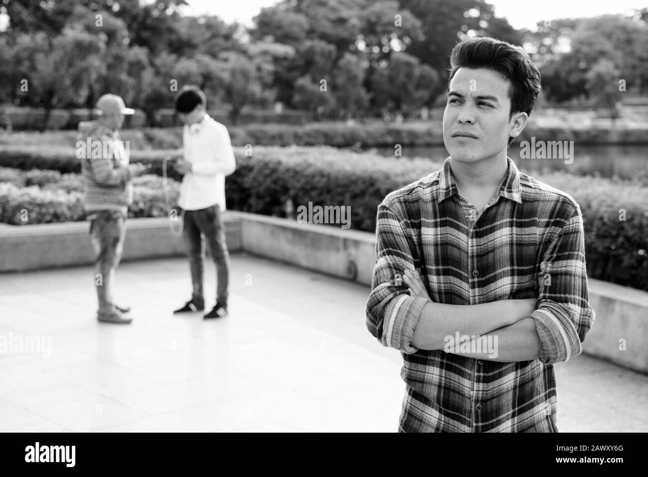 Tre giovani uomini asiatici di relax presso il parco insieme Foto Stock